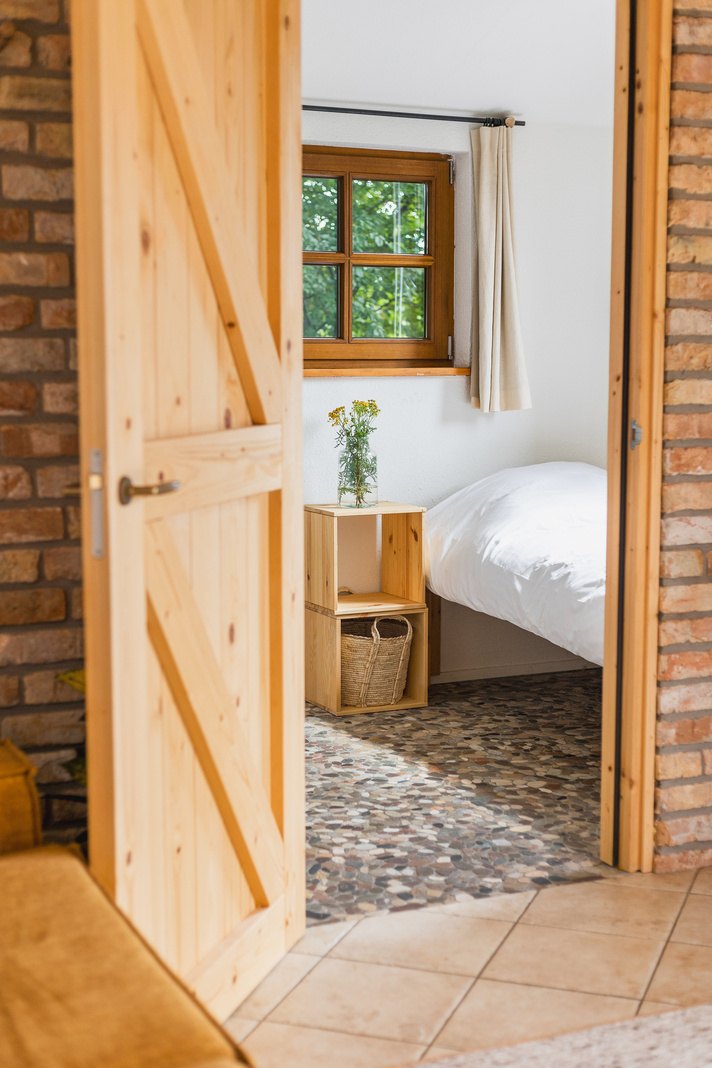 Warm, naturally lit guest room with wooden door